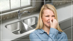 %Title% | Any Hour Services A woman pinches her nose in front of a kitchen sink, indicating a bad smell coming from the sink area.