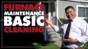 %Title% | Any Hour Services A man in a dress shirt and tie gestures toward a house entrance. Text reads: "Furnace Maintenance Basic Cleaning.