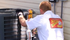 %Title% | Any Hour Services A technician in a white uniform inspects and repairs an outdoor air conditioning unit using tools and a meter.