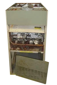 Old furnace with its front panel removed, revealing internal wiring and components. The exposed metal parts show signs of rust and wear.