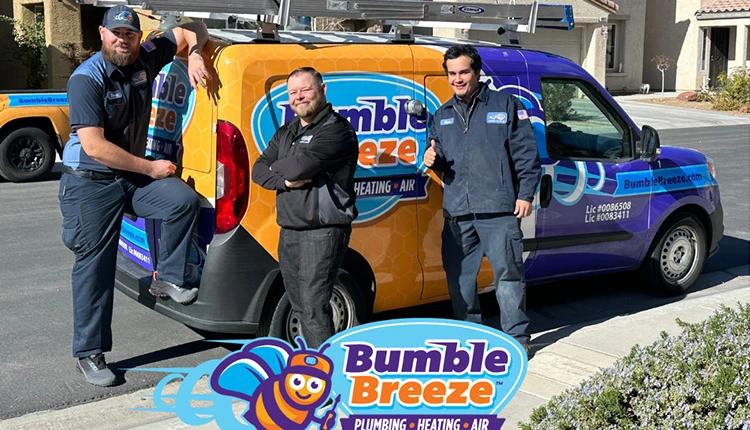 Three smiling technicians in uniforms stand by a colorful Bumble Breeze plumbing, heating, and air van, conveying professionalism and friendliness.