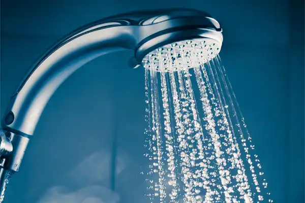 Close-up of a modern showerhead with water spraying out in multiple streams against a blue-toned background, highlighting the comfort and efficiency you expect after expert Tankless Water Heater Repair in Salt Lake City.