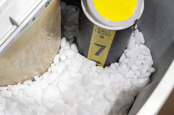A water softener brine tank filled with salt pellets in Salt Lake City, featuring a yellow salt level indicator marked at level 7—ideal for monitoring and ensuring timely water softener repair.