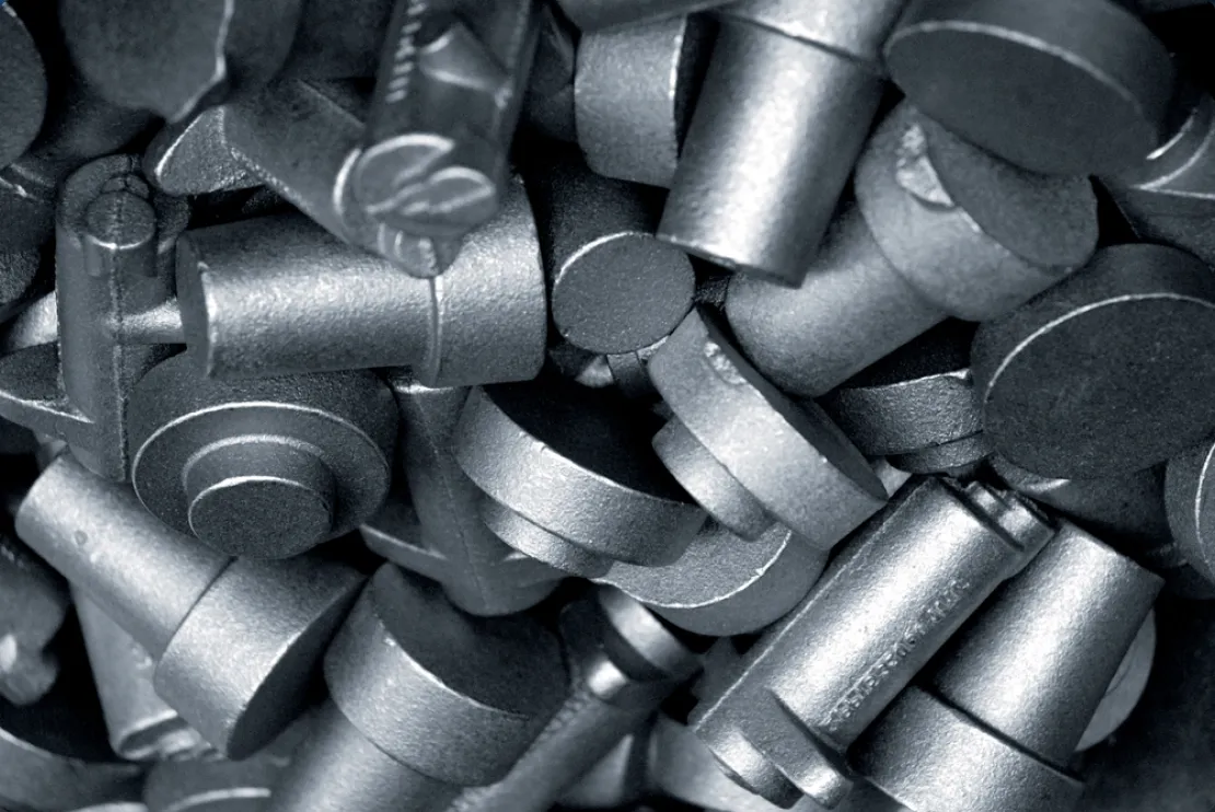 A close-up view of a pile of metallic industrial bolts and screws with a matte finish, commonly used in assembling sewer line materials and other heavy-duty applications.