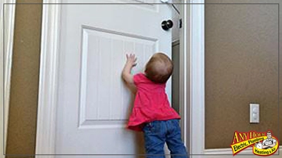 %Imagetitle% | Any Hour Services A small child in a pink shirt reaches up toward a closed white door. The scene hints at the importance of emergency plumbing awareness. There is a logo for Any Hour Electric, Plumbing, Heating & Air in the bottom right corner.