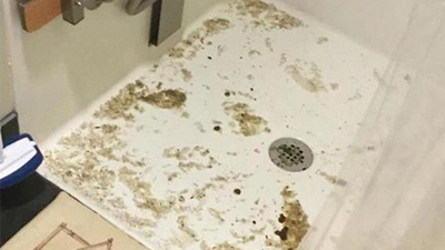 %Imagetitle% | Any Hour Services A shower floor with brown and yellow stains, dirt, and grime buildup near the drain and along the edges—signs that could point to common plumbing problems requiring prompt plumbing repair.