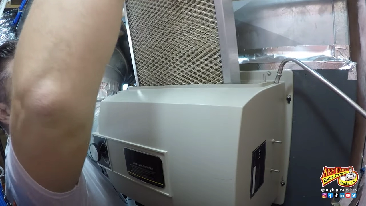 %Title% | Any Hour Services A person replaces a rectangular air filter in an HVAC furnace as part of winter furnace maintenance inside a building. The Any Hour Services logo is visible in the bottom right corner.