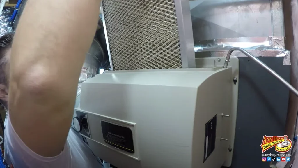 A person replaces an air filter in an HVAC unit; the Any Hour Services logo is visible in the bottom right corner.